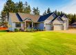 Blue craftsman home with double garage and manicured lawn
